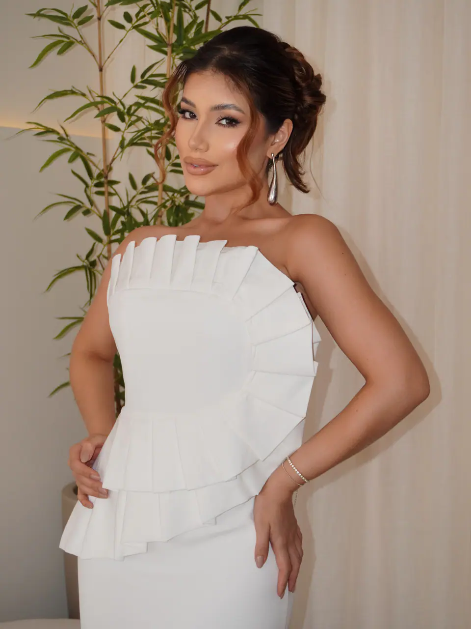 Modelo com o vestido branco plissado da Closet 181, dentro da loja